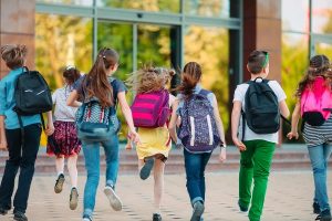 Kinder laufen in die Schule