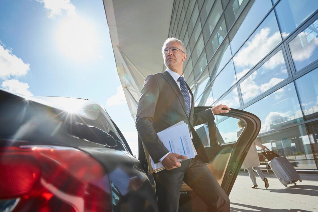 Geschäftsmann am Flughafen steigt aus Auto aus